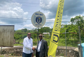 Member of Parliament for Hanover Eastern, Dave Brown (left), greets the Chief Executive Officer of the Universal Service Fund, Daniel Dawes, at the commissioning of a Wi-Fi hotspot in Hopewell on April 27.