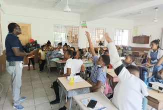 Technical Officer at the Jamaica Information Service (JIS) Montego Bay Regional Office, Kavanaugh Campbell (left), demonstrates to students at the Hosanna Preparatory School in St. James, how to use a video camera, during their career day exercise held on May 26. The JIS engaged the students in discussions about careers in media under the theme “Conquer Your Future Through Career Development.”

