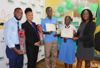 Executive Director of the Scientific Research Council (SRC), Dr. Charah Watson (right), makes a presentation to the team from Brown’s Town High School in St. Ann, at the awards ceremony for the 2022/2023 Young Inventors and Innovators Competition (YIIC), held on May 2 at the SRC’s Hope Gardens headquarters in St. Andrew. From left are Teachers, Alex Holmes and Molly Coombs and students Leroy Gallimore and Tamelia Thompson.