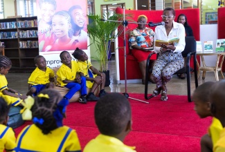 Chief Executive Officer, VM Foundation, Samantha Charles, reads a book to Elletson Road Basic School students during a Read Across Jamaica Day engagement at the Kingston and St. Andrew Parish Library on May 9. Read Across Jamaica Day is used annually to promote the significance of reading and literacy among Jamaicans. 