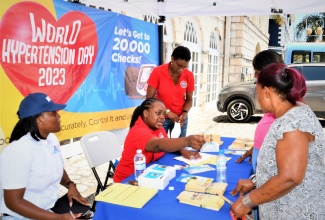 The National Health Fund (NHF) team provides instructions to members of the public during a free blood pressure check exercise in Sam Sharpe Square, Montego Bay, on Wednesday (May 17), to mark World Hypertension Day. 