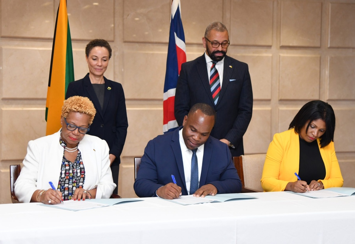 Minister of Foreign Affairs and Foreign Trade, Senator Hon. Kamina Johnson Smith (standing left) and Secretary of State for Foreign, Commonwealth and Development Affairs, United Kingdom (UK), the Rt. Hon. James Cleverly (standing right) observe the signing of a Memorandum of Understanding (MOU) between Jamaica and the British Council on co-operation in Science, Technology, Engineering, Arts and Mathematics (STEAM). The signatories (seated from left) are: Acting Permanent Secretary in the Ministry of Education and Youth, Maureen Dwyer; Executive Director, National Education Trust (NET), Latoya Harris Ghartey; and Country Director, Jamaica and the Caribbean Islands, British Council, Damion Campbell. The signing took place during a press conference following the Jamaica-United Kingdom strategic dialogue at the Ministry of Foreign Affairs and Foreign Trade’s downtown Kingston offices on May 19.