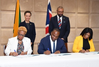 Minister of Foreign Affairs and Foreign Trade, Senator Hon. Kamina Johnson Smith (standing left) and Secretary of State for Foreign, Commonwealth and Development Affairs, United Kingdom (UK), the Rt. Hon. James Cleverly (standing right) observe the signing of a Memorandum of Understanding (MOU) between Jamaica and the British Council on co-operation in Science, Technology, Engineering, Arts and Mathematics (STEAM). The signatories (seated from left) are: Acting Permanent Secretary in the Ministry of Education and Youth, Maureen Dwyer; Executive Director, National Education Trust (NET), Latoya Harris Ghartey; and Country Director, Jamaica and the Caribbean Islands, British Council, Damion Campbell. The signing took place during a press conference following the Jamaica-United Kingdom strategic dialogue at the Ministry of Foreign Affairs and Foreign Trade’s downtown Kingston offices on May 19.