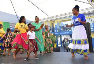 Minister of Culture, Gender, Entertainment and Sport, Hon. Olivia Grange (centre), dances alongside the Charles Town maroons during Africa Day celebrations at Buff Bay Primary School in Portland, on Thursday (May 25).