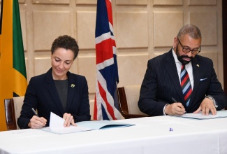 Minister of Foreign Affairs and Foreign Trade, Senator the Hon. Kamina Johnson Smith (left) and Secretary of State for Foreign, Commonwealth and Development Affairs of the United Kingdom, the Rt. Hon. James Cleverly, sign a framework document for a £15-million ($2.9-billion) violence-prevention project, during a press conference following a JA-UK strategic dialogue at the Ministry’s downtown Kingston offices on May 19.