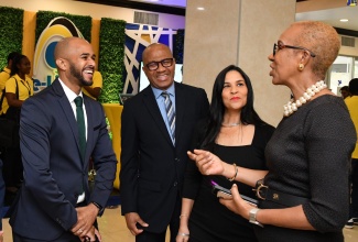 Minister of Education and Youth, Hon. Fayval Williams (right), speaks with (from left) Managing Director, Smart Mobile Solutions, Dane Spencer; Chief Executive Officer, e-Learning Jamaica, Andrew Lee and Samsung Executive, Rosa Neris Baez, during Wednesday’s (May 24) opening ceremony for the two-day Technology in Education Conference. The event is being held at The Jamaica Pegasus hotel in Kingston.