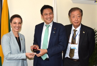 Minister of Foreign Affairs and Foreign Trade, Senator the Hon. Kamina Johnson Smith (left), receives a gift from State Minister for Foreign Affairs, Japan, Takei Shunsuke, before the start of a bilateral meeting held at The Jamaica Pegasus hotel on May 17. At right is Japan's Ambassador to Jamaica, His Excellency Yasuhiro Atsumi.

