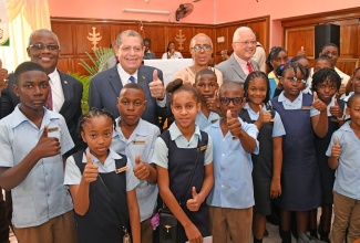 Minister of Education and Youth, Hon. Fayval Williams (background, third left), gives the thumbs up at the launch of the Manchester School Peace Ambassadors initiative at the Zorn Moravian Church in Christiana on Friday, June 9. She is joined by (from left, background) Custos of Manchester,  Garfield Green; Member of Parliament, Manchester North East, Audley Shaw;  Minister of Justice, Hon. Delroy Chuck, and students from the Christiana High and Christiana Moravian Primary and Infant schools, who will serve as the first peace ambassadors. 