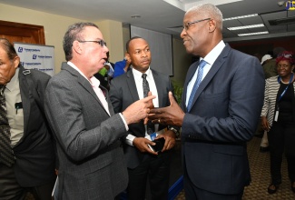 Minister of Science, Energy, Telecommunications and Transport, Hon. Daryl Vaz (left), speaks with former Commissioner of Police, Owen Ellington (right) at Thursday’s (June 15) Transport Authority Transportation Conference 2023 at the University of the West Indies Regional Headquarters in Mona, St. Andrew. Sharing in the conversation is the Transport Authority’s Managing Director, Ralston Smith. 