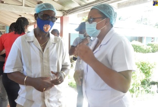 Minister of Local Government and Community Development, Hon. Desmond McKenzie (left), converses with Matron at the St Ann Infirmary, Alicia Drummond-Knight, during a tour of the facility on Friday (August 18).