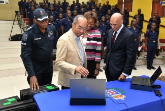 Deputy Prime Minister and Minister of National Security, Hon. Dr. Horace Chang (second left), examines one of several computers, valued US$700,000, that were acquired for the Jamaica Constabulary Force (JCF) under the National Security Ministry’s Security Strengthening Project (SSP). The computers were funded by the Inter-American Development Bank (IDB). Others (from left) are Senior Superintendent of Police Aaron Fletcher; Permanent Secretary in the National Security Ministry, Ambassador Alison Stone Roofe, and Police Commissioner, Major General Antony Anderson. The handover ceremony was held at the National Police College of Jamaica (NPCJ) in St. Catherine on Wednesday (July 19).