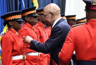 Governor- General, His Excellency the Most Hon. Sir Patrick Allen, pins the 2022 Medal of Honour for General Service on JDF Private Denton S. during the JDF’s Armed Forces Day presentation ceremony on Monday, July 31 at Up Park Camp in Kingston.