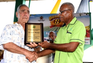 Outgoing First Vice-President of the Jamaica Agricultural Society (JAS), Denton Alvaranga (right), receives a plaque from Custos of Clarendon, Hon. William Shagoury, for his more than 35 years of service to the sector, at the recent 69th Denbigh Agricultural, Industrial and Food Show, held at the Denbigh Showground in Clarendon.