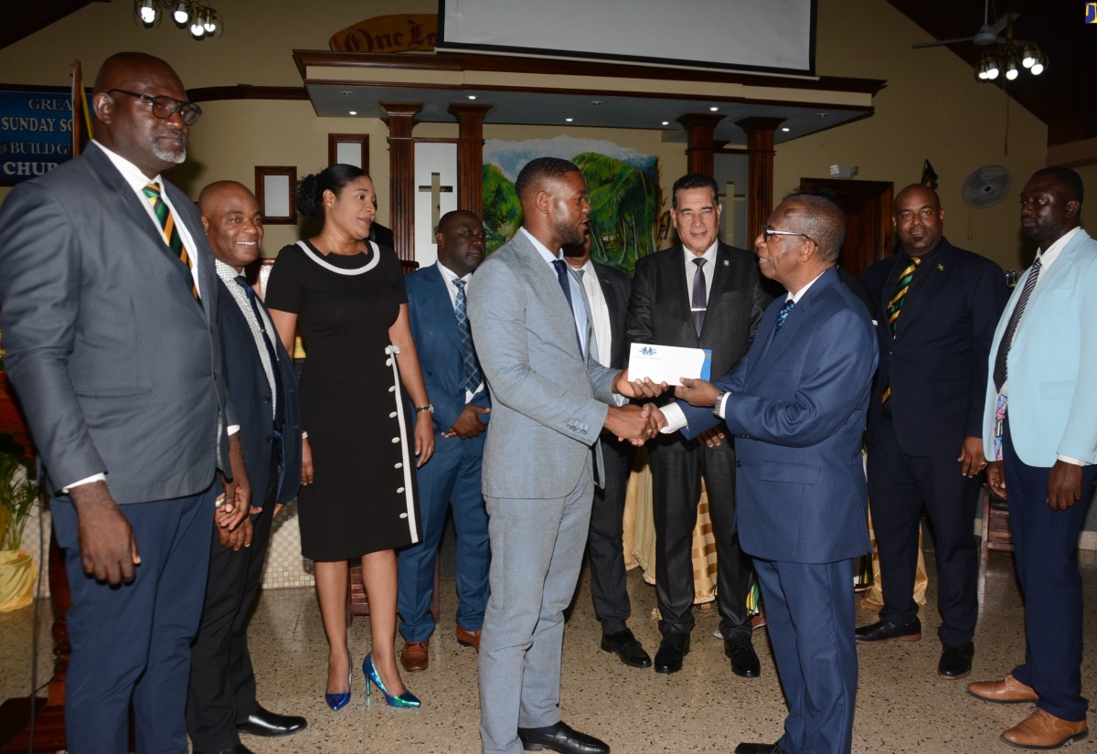 Deputy Mayor of Montego Bay, Councillor Richard Vernon (left), hands over a token of appreciation to Pastor of the Kings Chapel United Pentecostal Church, Frank Kellier, during the St. James Independence Church Service, held at the church on Albion Road in Montego Bay, on Sunday (July 30). They are joined by Minister of State in the Office of the Prime Minister (West), Hon. Homer Davis (third right, back row), and Councillors from St. James.