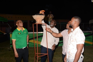 Custos Rotulorum for St. James, Bishop the Hon. Conrad Pitkin (second left), lights a flame during the Emancipation vigil at Jarrett Park in Montego Bay at midnight (August 1). The act symbolised the igniting of the flames of freedom by plantation slaves in Kensington, St. James, and other parts of Jamaica. Also participating in the exercise are (from left) Government Senator, Charles Sinclair; Councillor, Maroon Town Division, Everes Coke; and Deputy Mayor of Montego Bay, Councillor Richard Vernon.
