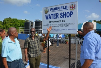 Minister of Local Government and Community Development, Hon. Desmond McKenzie (third left), points to the sign for the $12-million Fairfield water shop in St. Elizabeth, which was commissioned on Monday, August 21. Others (from left) are Mayor of Black River, Councillor Derrick Sangster; Minister of State in the Ministry of Agriculture, Fisheries and Mining and Member of Parliament for the area, Hon. Franklin Witter, and Councillor for the Myersville Division, Layton Smith.