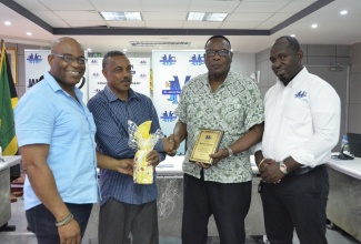 Mayor of Montego Bay and Chairman of the St. James Municipal Corporation, Councillor Leeroy Williams (second right), makes a presentation to Shelter Manager, Mocho Community Centre, Richard Bennett (second left), during a Shelter Management Conference held at the Municipal Corporation on June 6. Also sharing the moment are (from left) Councillor for the Maroon Town Division, Everes Coke and Councillor for Montego Bay South Eastern division and Chairman of the Corporation’s Disaster Management Committee, Arthur Lynch.