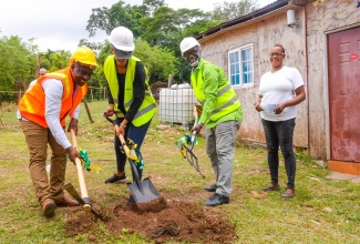 Minister of Local Government and Rural Development, Hon. Desmond McKenzie (second right), breaks ground for an indigent house in Kendal, Manchester, on August 2, beneficiary, Nadine Lawrence (right). Others participating are (from left) Mayor of Mandeville, Councillor Donovan Mitchell and Member of Parliament for Manchester Central, Rhoda Moy Crawford.