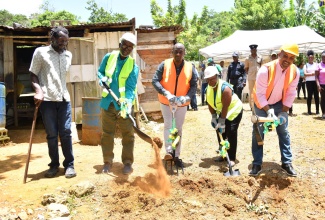 Minister of Local Government and Community Development, Hon. Desmond McKenzie (second left), along with (from third left) Mayor of Mandeville, Councillor Donovan Mitchell; Councillor for the John's Hall Division, Faith Sampson; and Member of Parliament for North West Manchester, Mikael Phillips, break ground for a one-bedroom indigent housing solution in Coley Mountain, Manchester on July 7. Looking on is beneficiary of the housing solution, Leroy Dwyer.