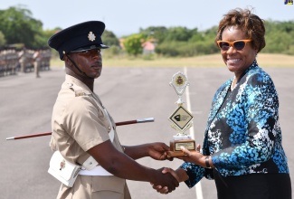 Permanent Secretary in the Ministry of National Security, Ambassador Alison Stone Roofe (right), presents the Commandant’s Award to Private (NS) R. Richards, for achieving the highest overall average during training. Occasion was the Passing Out Parade for the Jamaica National Service Corps (JNSC) Intake 2022/02, held on Friday (July 21) at the Polo Grounds, Up Park Camp in Kingston.