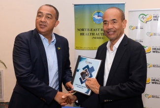 Minister of Health and Wellness, Dr. the Hon. Christopher Tufton (left) and Chairman of the Southern Regional Health Authority (SRHA), Wayne Chen, highlight the Service Level Agreement and Medical Equipment Maintenance Policy, at a signing ceremony held on August 15 at The Jamaica Pegasus hotel in New Kingston.