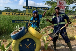 Customer Relations Officer at WPM Waste Management Limited, Sharnon Williams (left), and WPM Sanitation Officer, Roshaun Dick, participate in beautification work after the agency eliminated a dump site in Clark’s Town, Trelawny on Wednesday (July 26).  