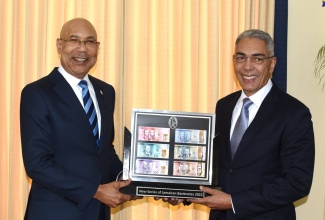 Governor-General, His Excellency the Most Hon. Sir Patrick Allen (left), receives a framed collection of the new series of banknotes from Governor, Bank of Jamaica (BOJ), Richard Byles. The BOJ Governor, along with other representatives from the Bank, visited King’s House on August 15.