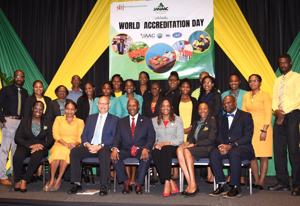 Minister of Industry, Investment and Commerce, Senator the Hon. Aubyn Hill (centre, seated), with executives of the Jamaica National Agency for Accreditation (JANAAC) during the entity’s CEO Breakfast at The Jamaica Pegasus hotel in New Kingston on June 9, where three public and private-sector entities received accreditation to ISO/IEC 17025 Standard. From left (seated) are JANAAC’s Director of Planning, Strategic Development and Promotions, Cassetta Green; Director of Accreditation, Gabrielle Andrade-Bell; Chairman, Simon Roberts; Chief Executive Officer, Sharonmae Shirley; Senior Director of Accreditation, Training and Quality Management, Dr. Yvette Castell; and Director of Finance and Administration, Garfield Bassett. Standing are representatives of the entities – the Jamaica Public Service Company Limited (JPS), National Water Commission (NWC), and National Compliance and Regulatory Authority (NCRA).