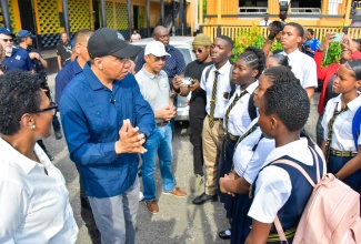 Prime Minister, the Most Hon. Andrew Holness (second left), interacts with students of Kingston Technical High School on Friday (September 15) during a visit to the institution while touring several communities in downtown Kingston where the Project STAR (Social Transformation and Renewal) initiative is being implemented. The Prime Minister is accompanied by (from left) President and Chief Executive Officer, Scotia Group Jamaica, Audrey Tugwell Henry, and Deputy Prime Minister and Minister of National Security, Hon. Dr. Horace Chang.
