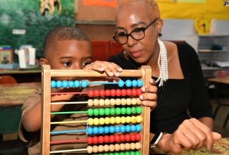 Minister of Education And Youth, Hon. Fayval Williams (right), observes as grade-one student at Mountain View Primary and Infant School in Kingston, Everett Austin, demonstrates his mathematics skills using an abacus. Minister Williams visited students, staff and parents at the institution on Monday (September 4) to observe activities for the start of the 2023/24 academic year.

