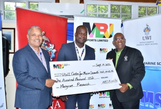 Director, University of the West Indies (UWI) Centre for Marine Sciences, Professor Dale Webber (right), receives a cheque for US$100,000 from Chief Executive Officer (CEO) at MBJ Airports Limited, Shane Munroe (centre) and President and Chief Executive Officer at the Airports Authority of Jamaica (AAJ), Audley Deidrick,  to support mangrove research initiatives. The handover ceremony was held on September 19 at the Discovery Bay Marine Lab in St Ann.

