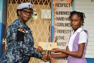 Jamaica Defence Force (JDF) Warrant Officer and member of the Red Hills Primary School Past Students’ Association, Angi Lisa Chambers (left), makes a presentation to Christeanna Walters. Occasion was a ceremony at the institution on September 26 to hand over grants totalling $100,000 to 10 former students who performed well in the recent Primary Exit Profile (PEP) examinations.