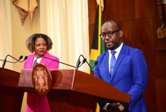 Minister without Portfolio with Responsibility for Skills and Digital Transformation, Senator Dr. the Hon. Dana Morris Dixon, looks on as Programme Director, National Identification System (NIDS), Dr. Warren Vernon, gives an update on the project at the post-Cabinet press briefing on Wednesday (October 25) at Jamaica House.

