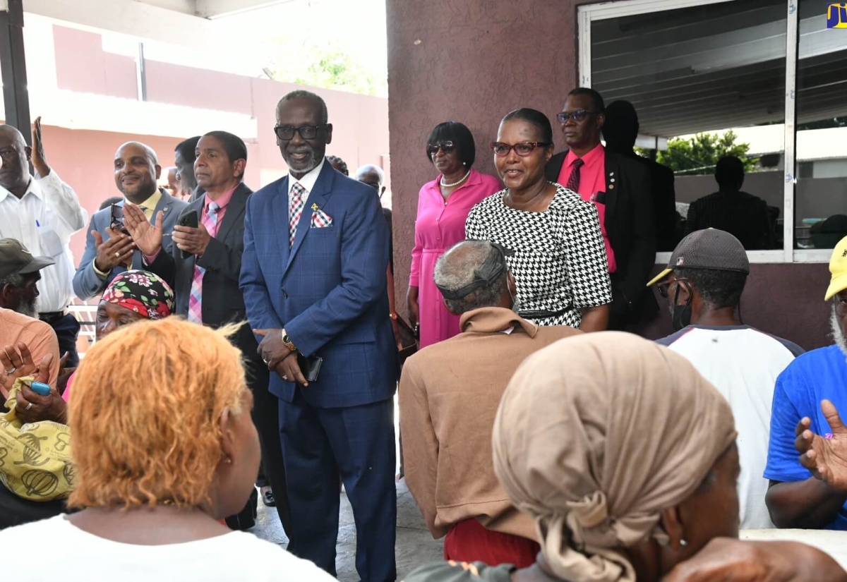 Minister of Local Government and Community Development, Hon. Desmond McKenzie (centre), with clients and staff of the Desmond McKenzie Transitional Centre for the Homeless. Minister McKenzie visited the shelter located on King Street in Kingston during a ceremony to commemorate World Homeless Day on Tuesday (October 10). Others (from left) are Town Clerk, Kingston and St. Andrew Municipal Corporation (KSAMC), Robert Hill; Mayor of Kingston and KSAMC Chairman, Senator Councillor Delroy Williams; and Inspector of Poor, Kingston and St. Andrew, Mavis Farquharson.