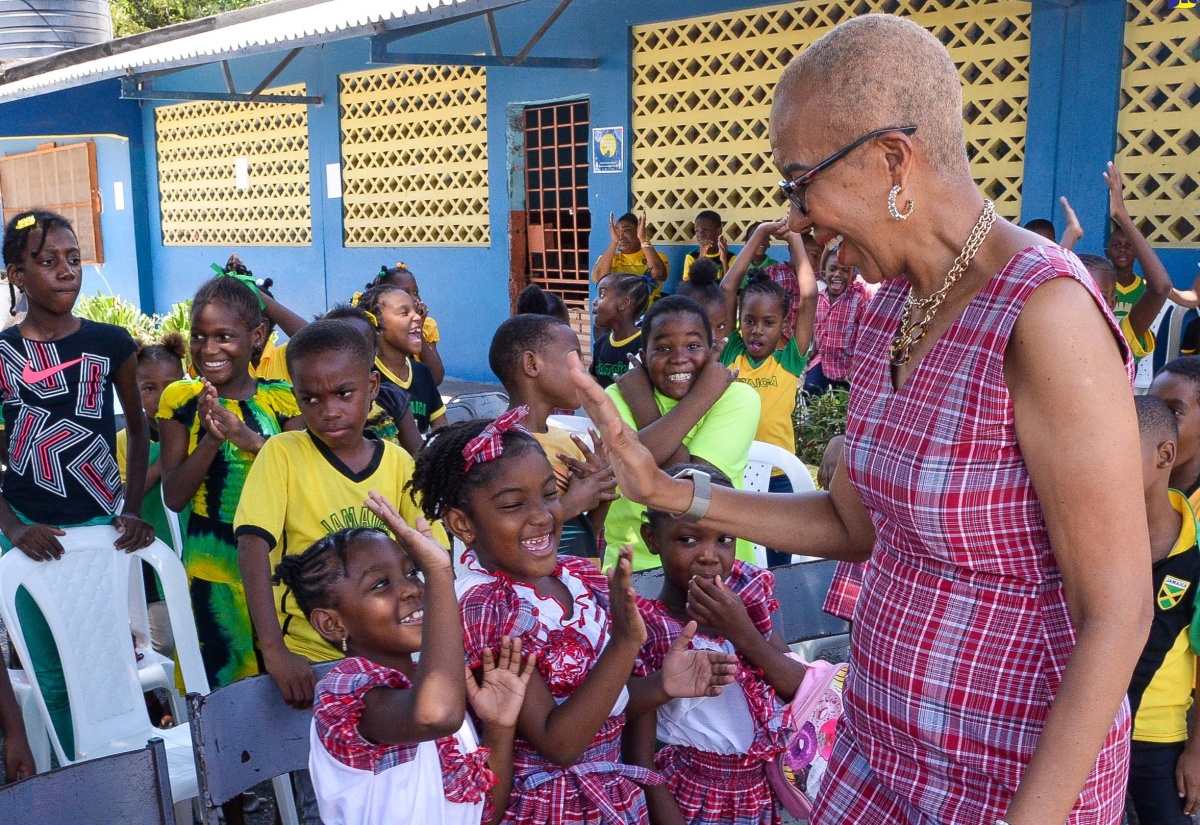 Minister of Education and Youth, Hon. Fayval Williams, gives high-fives to students at St. Andrew Primary School, during a visit to share in the Heritage Day celebrations at the institution in Kingston on October 12.