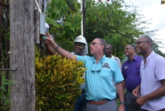 Minister of Science, Energy, Telecommunications and Transport, Hon. Daryl Vaz (second left),  inspects a Jamaica Public Service (JPS) meter in Prospect, Westmoreland, during a tour on Friday, September 29. With the Minister (from left) are Regional Operations Manager, JPS,  David Lewis; State Minister in the Ministry,  Hon. J.C. Hutchinson; Managing Director, Jamaica Social Investment Fund (JSIF), Omar Sweeney; and Member of Parliament for Westmoreland Western, Morland Wilson.