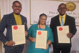 Three of six senior officials at the Ministry of Health and Wellness who have been commissioned to serve as Justices of the Peace (JPs) display their appointment seals at a recent commissioning ceremony held at the Terra Nova All-Suite Hotel in St. Andrew. They are (from left) Director of Communication in the Ministry, Stephen Davidson; Regional Technical Director at the South East Regional Health Authority (SERHA), Dr. Sandra Chambers, and Scientific Officer at the Ministry, Livingston Burnett.