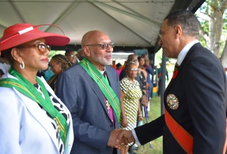 Prime Minister, the Most Hon. Andrew Holness (right), greets recipient of the Order of Jamaica (OJ), Anglican Archbishop of the West Indies, His Grace, the Most Reverend Howard Gregory (second left), during the Ceremony of Investiture and Presentation of National Honours and Awards, held on the lawns of King’s House on Monday (October 16). Sharing in the moment is fellow OJ recipient and reggae songbird, Marcia Griffiths (left). 