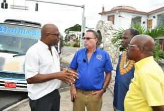 Minister of Science, Energy, Telecommunications and Transport, Hon. Daryl Vaz (second left), listens intently to President, Jamaica Association of Transport Owners and Operators (JATOO), Louis Barton (left), during a tour of sections of the Corporate Area on Monday (October 9) to observe activities in the public transport sector. Sharing in the conversation are President of Transport Operators Development Sustainable Services (TODSS), Egerton Newman (second right); and Vice President of JATOO, Everton Style.