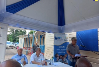 Chairman of the Western Regional Health Authority (WRHA) Eric Clarke, addresses residents, healthcare workers and other stakeholders at the recent ceremony for the adoption of the Ulster Spring Health Centre in Trelawny. Seated (left to right) are Custos of Trelawny, Hugh Gentles; and President of the Jamaica Organization of New Jersy and Donor, Owen Eccles. The facility is one of 46 that have been adopted through the Ministry of Health and Wellness’ Adopt-a-Clinic initiative throughout the island.

