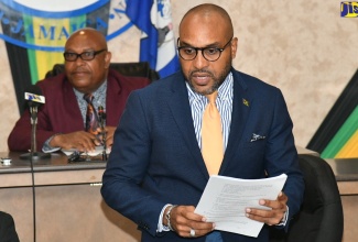 Chief Executive Officer, Kingston and St. Andrew Municipal Corporation (KSAMC), Robert Hill (foreground) addressing Tuesday’s (November 14) sitting of the KSAMC. The meeting was held at the Corporation’s offices on Church Street, downtown Kingston. Listening is Deputy Mayor of Kingston, Councillor Winston Ennis.

