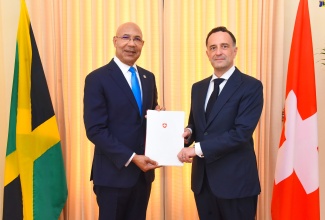 Governor-General, His Excellency the Most Hon. Sir Patrick Allen (left), receives a Letter of Credence from Ambassador-designate of the Swiss Confederation, Stefano Vescovi, during a courtesy call at King’s House on Thursday (November 23).

