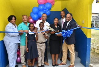 State Minister in the Ministry of Education and Youth, Hon. Marsha Smith (second right) is assisted by Managing Director of the Jamaica Social Investment Fund (JSIF), Omar Sweeny (right) to cut the ribbon to officially open the new classroom block at Grange Hill Primary School in Westmoreland on Thursday (November 2). Sharing in the moment are (from left) Regional Director in the Ministry of Education and Youth, Region 4, Dr. Michelle Pinnock; Grange Hill Primary board chairman, Samuel Williams; Head Girl at the institution, Kenneise Sortie; Head Boy, Theomar McKenzie; Member of Parliament for Westmoreland Western, Morland Wilson and Principal, Clayton Smith.