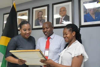 CEO/Commissioner at the Jamaica Customs Agency (JCA), Velma Ricketts Walker (left); Sean Barrow, ISO Project Director (centre); and Celia Russell-Henry, ISO Project Manager, examine the ISO 9001:2015 Certificate awarded to Jamaica Customs – the country's trade, revenue and border regulatory agency, at its Kingston head office. 