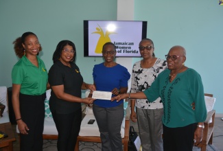 President of the Jamaica Women of Florida (JWOF), Janice McIntosh (second left), and JWOF’s Vice President, Aisha Rainford (left), hand over the US$12,500 cheque to Operations Manager of the Montego Bay Community Home for Girls, Yvette Mahoney (centre). They are joined by the Home’s Administrative Assistant, Carol James (second right), and Director, Christine Dexter.

