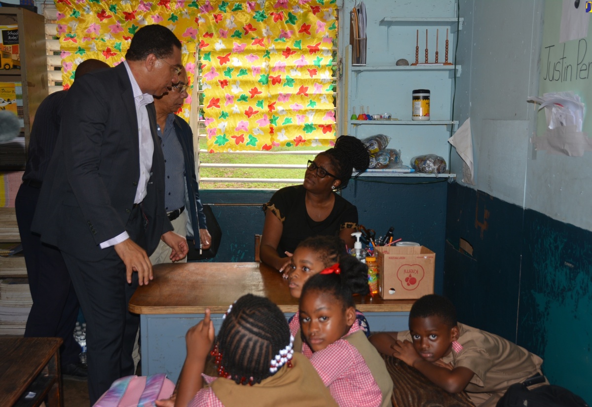 Prime Minister, the Most Hon. Andrew Holness (left) and Deputy Prime Minister and Minister of National Security, Hon. Dr. Horace Chang, console teacher Marila Nation, who taught one the two slain students of Chetwood Memorial Primary and Infant School in St. James, during a visit to the institution on Thursday, November 9.

 