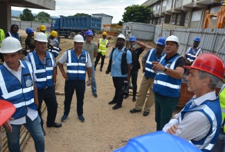 Minister of Health and Wellness, Dr. the Hon. Christopher Tufton, points out something of interest during a tour of the Western Children Adolescent Hospital project site with members of the Montego Bay business community on Tuesday (November 28).