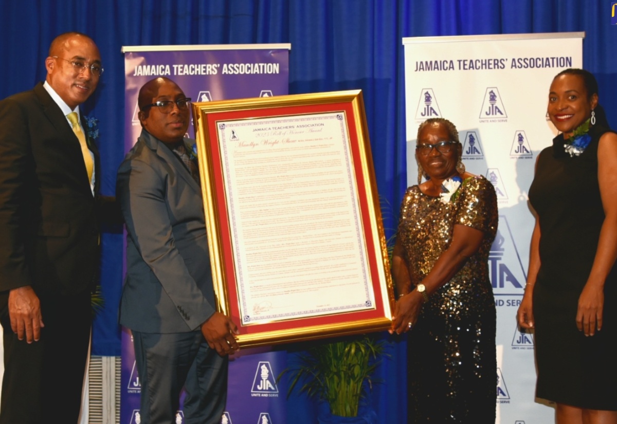 Minister of State in the Ministry of Education and Youth, Hon. Marsha Smith (right), shares in the presentation of a framed citation to the Jamaica Teachers’ Association (JTA) 2023 Roll of Honour Awardee,  Maudlyn Wright Shaw (second right), at the recent awards ceremony held at The Jamaica Pegasus hotel in New Kingston. Making the presentation is JTA President, Leighton Johnson (second left), while Attorney-at-law, Peter Champagnie, who was the guest speaker, also shares the moment.

