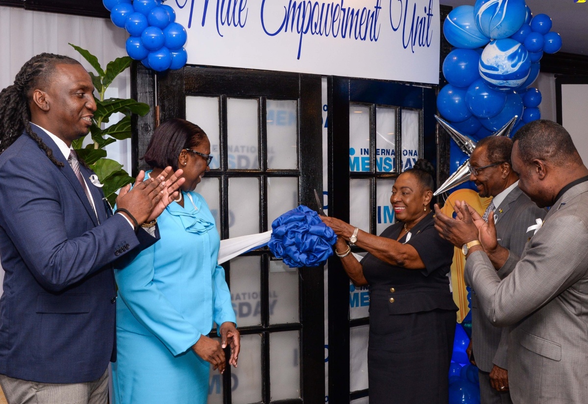 Minister of Culture, Gender, Entertainment and Sport (MCGES), Hon. Olivia Grange, cuts the ribbon to mark the symbolic opening of the Male Empowerment Unit, during a ceremony at The Jamaica Pegasus hotel in New Kingston on Wednesday (November 22). The Unit is located at the Bureau of Gender Affairs (BGA), 5-9 South Odean Avenue. Looking on (from left) are Acting Director, Male Empowerment, BGA, Nashan Miller; Principal Director in the Ministry, Sharon Coburn Robinson; United States Ambassador to Jamaica, His Excellency Nick Perry; and Permanent Secretary in the Ministry, Dean-Roy Bernard.

