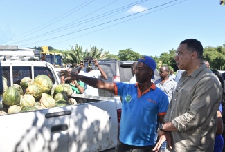 Prime Minister, the Most Hon. Andrew Holness (right), is in conversation with St. Thomas farmer, Garfield Espeut, during a tour of sections of the parish today (November 19), to look at the effects of the recent heavy rains.